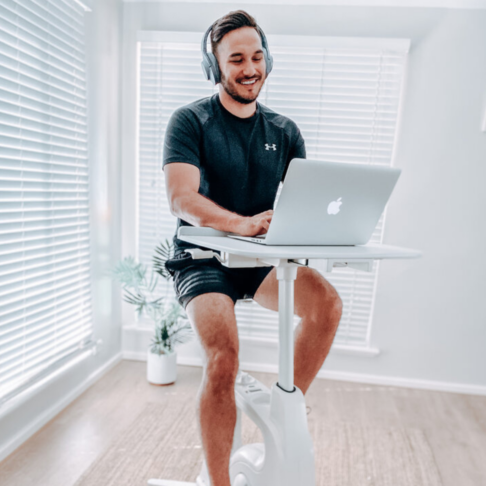 man using laptop on a bikedesk in a bright room